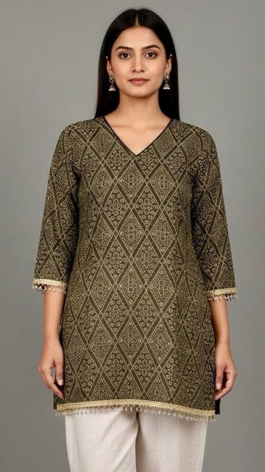 Woman wearing a green patterned kurta with white pants against a gray background