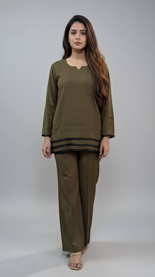 Woman wearing an olive green outfit on a plain background