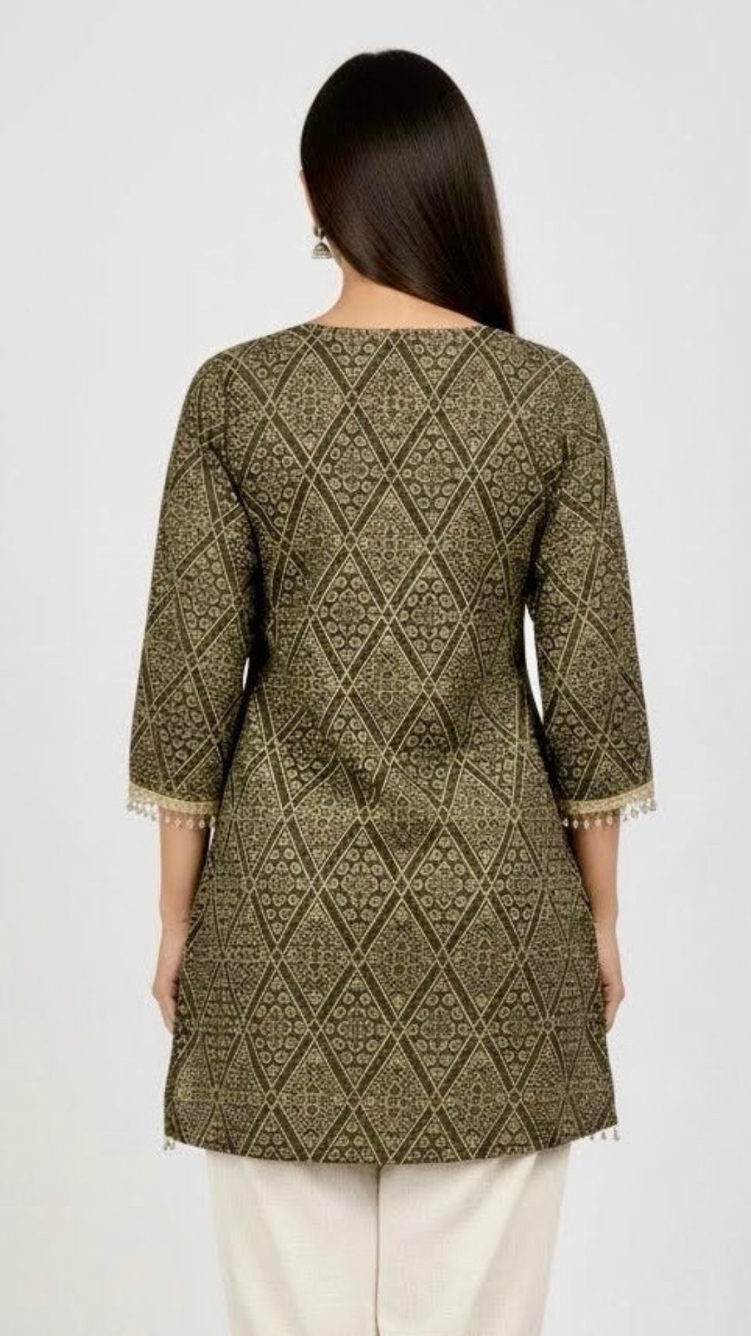 Woman wearing a patterned green kurta with white pants on a white background