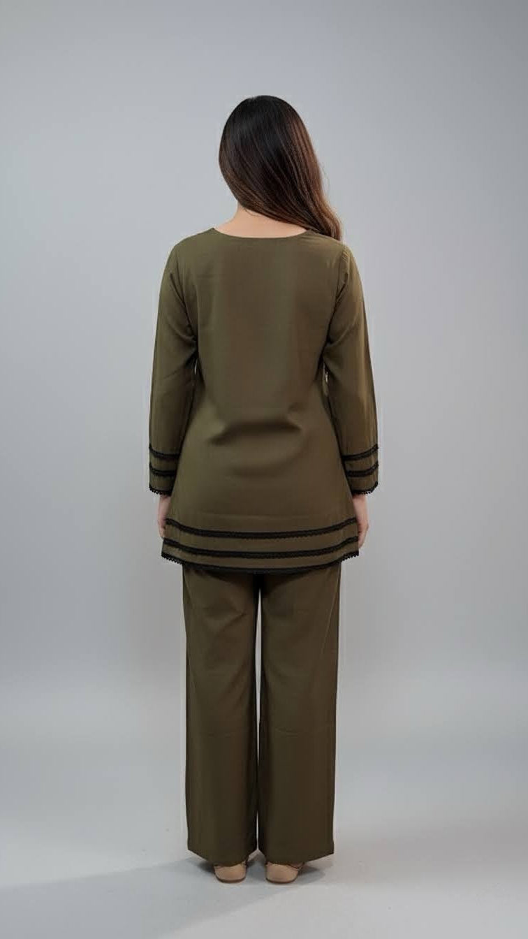 Woman wearing an olive green outfit with a matching top and pants on a plain background