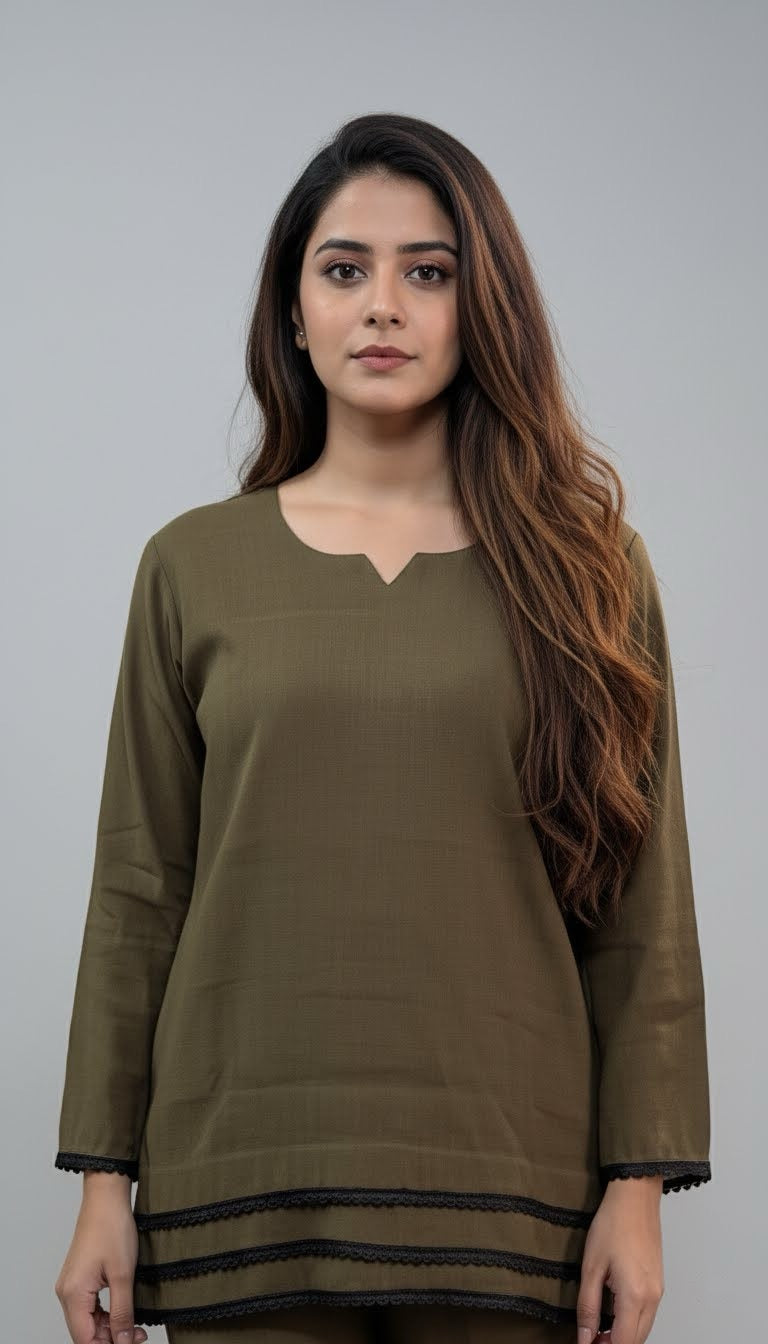 Woman wearing an olive green top with black trim on a gray background