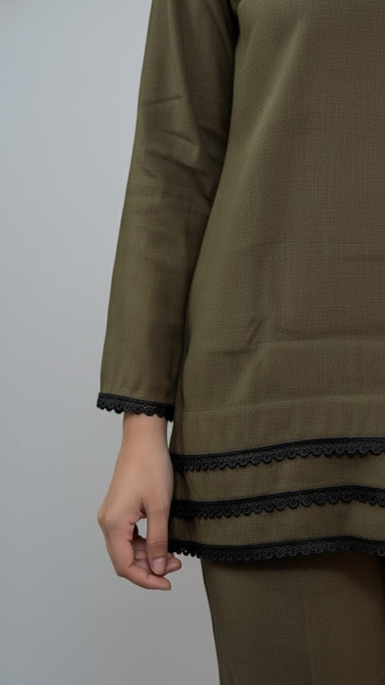 Olive green outfit with black lace trim on a plain background