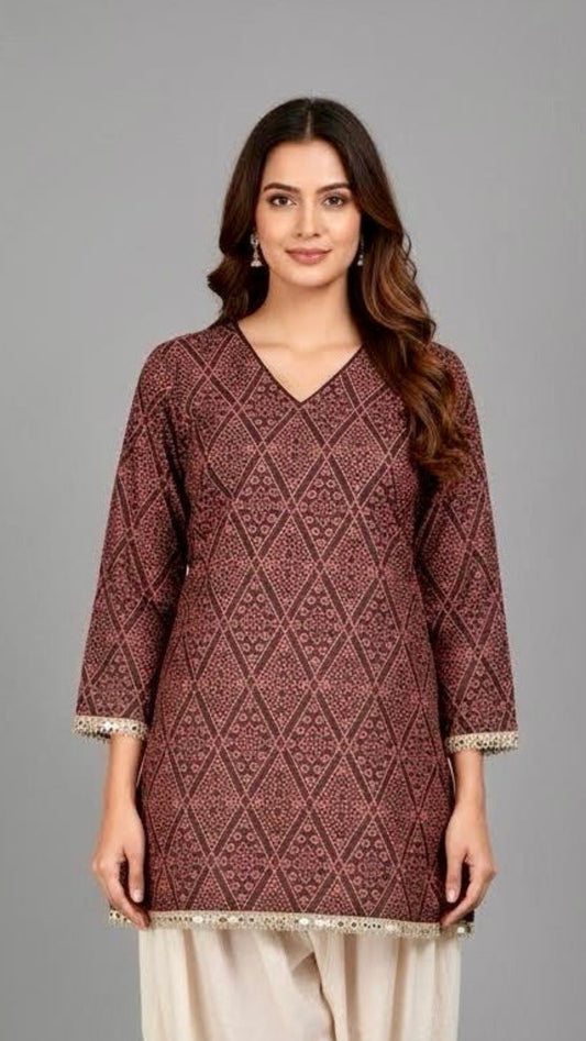 Woman wearing a brown patterned kurta with white dhoti on a gray background
