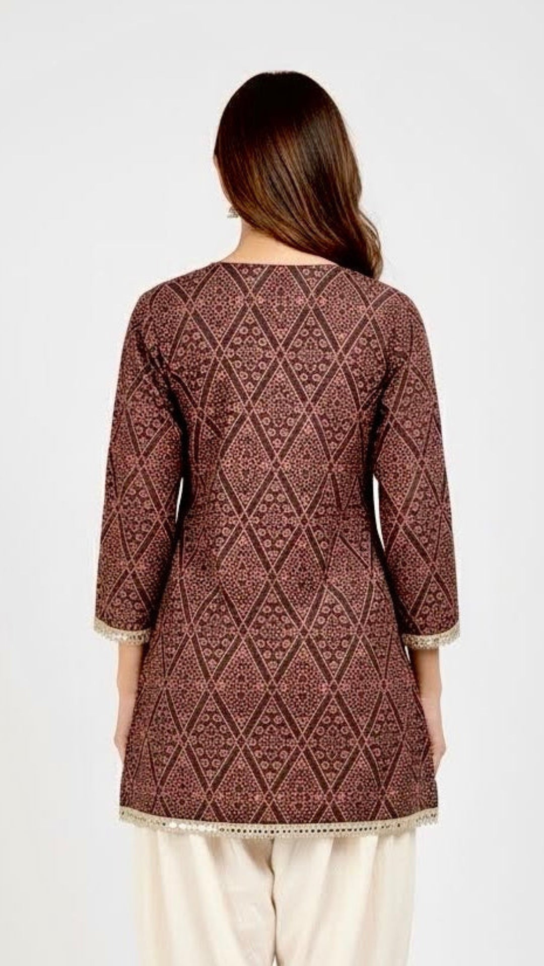Woman wearing a brown patterned kurta with white pants on a white background