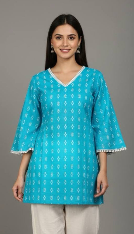 Woman wearing a blue patterned kurta with white pants on a gray background