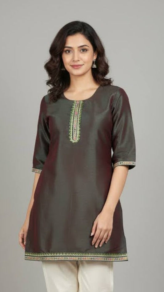 Woman wearing a dark green kurta with white pants on a gray background