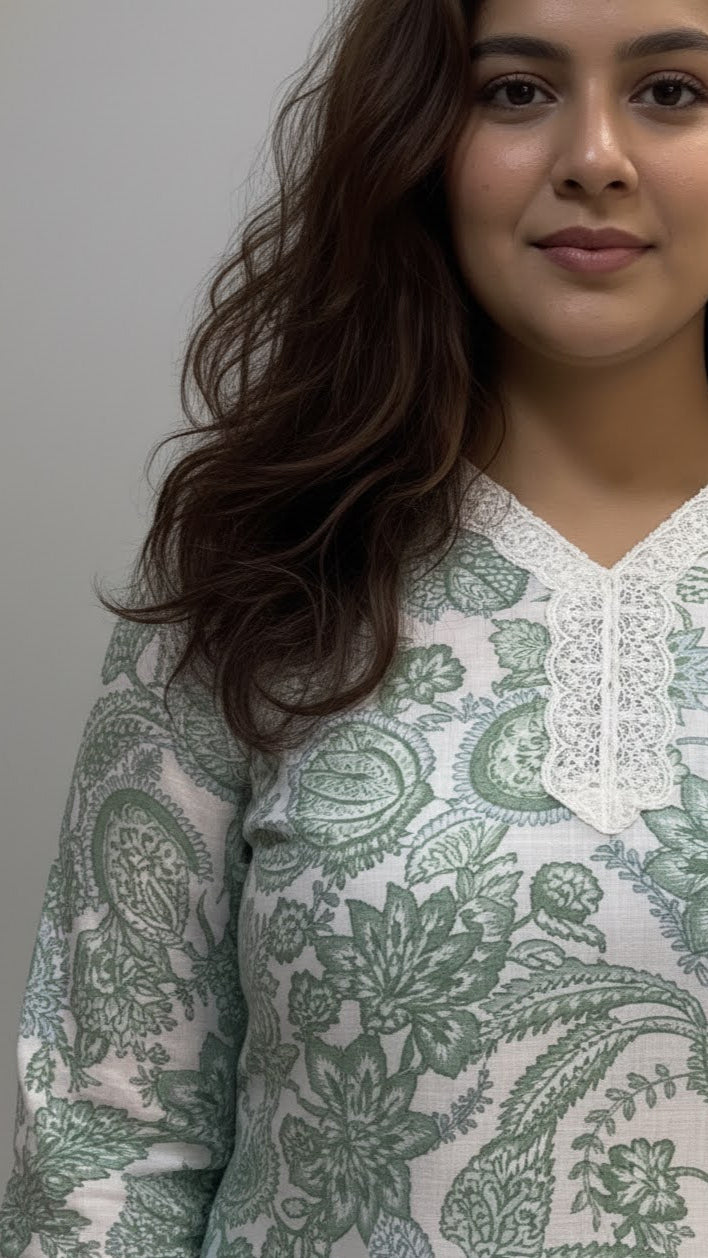 Woman wearing a green and white patterned top against a plain background