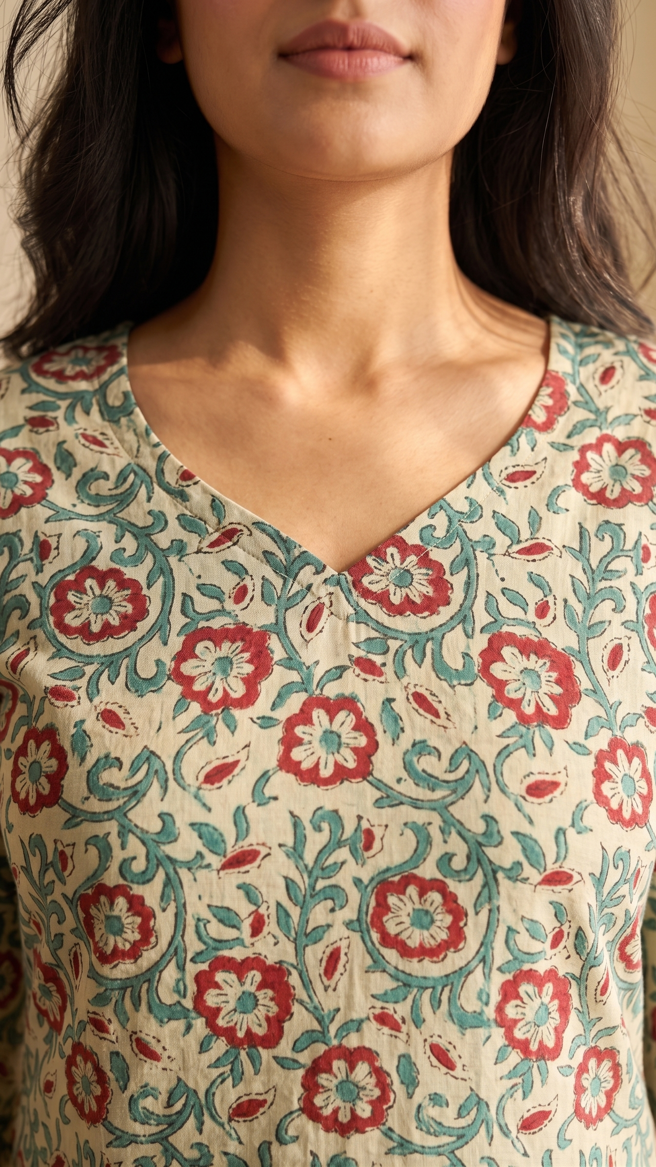 Woman wearing a floral patterned top with a neutral background