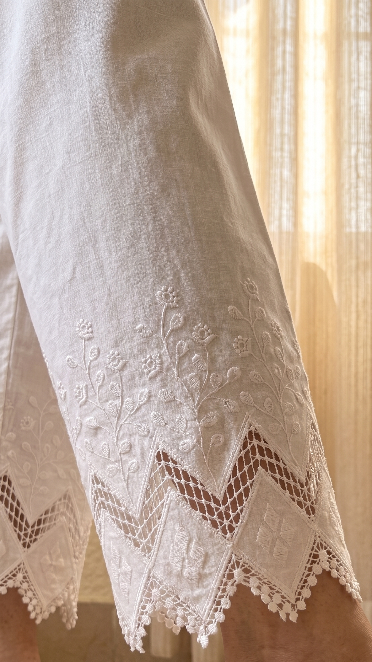 Close-up of white embroidered pants with a blurred background