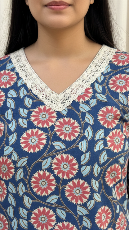 Close-up of a person wearing a floral patterned top with lace neckline.