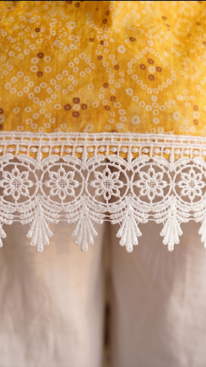 Close-up of a yellow fabric with white lace trim