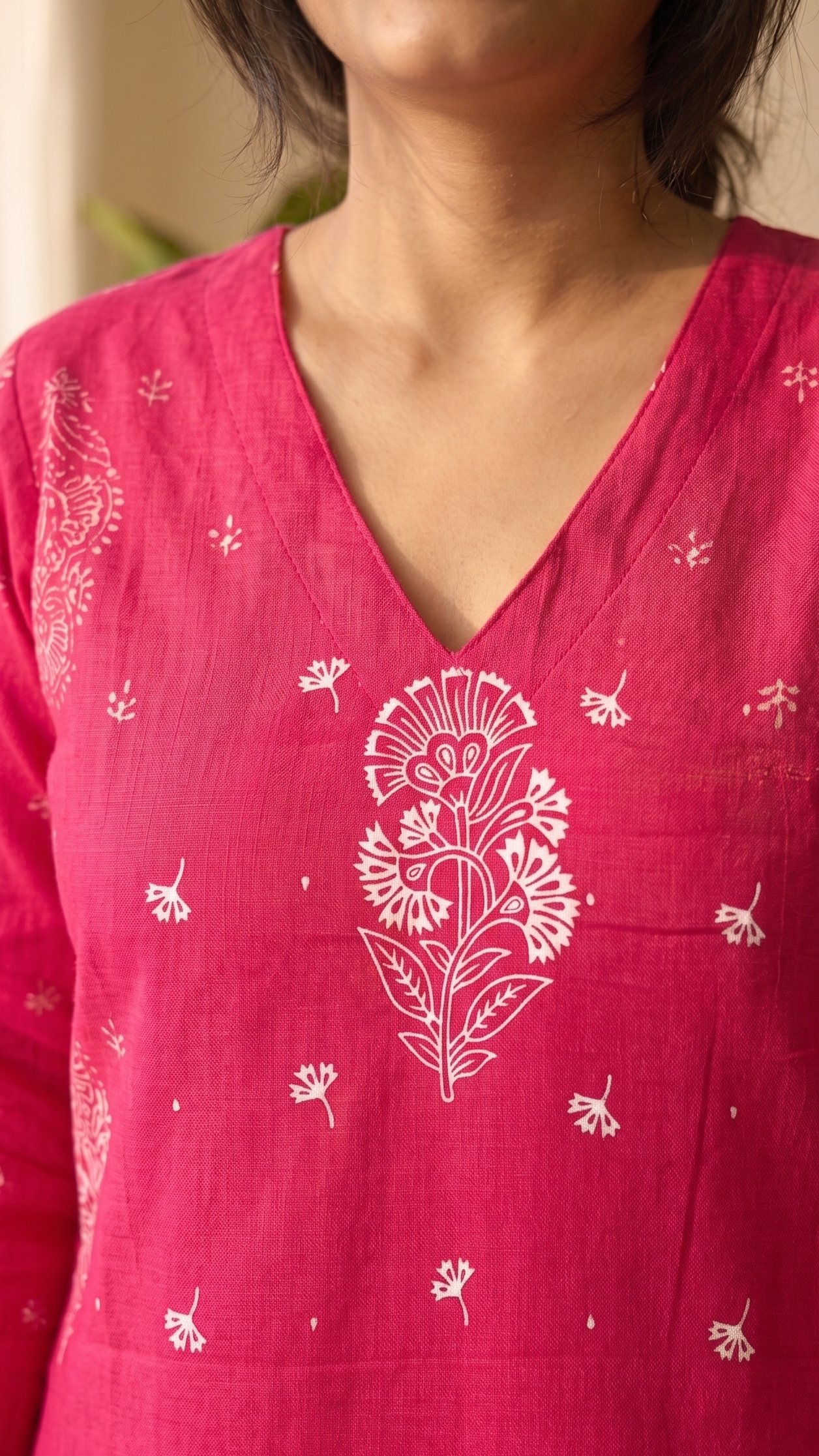 Person wearing a pink kurta with white floral patterns