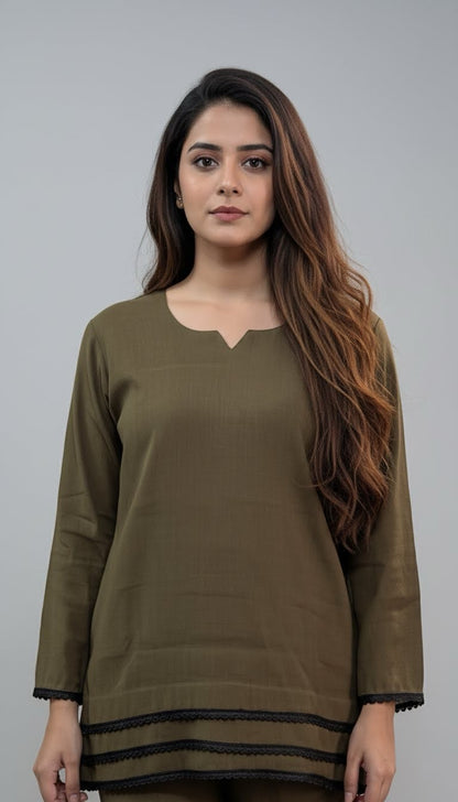 Woman wearing an olive green top with black trim on a gray background