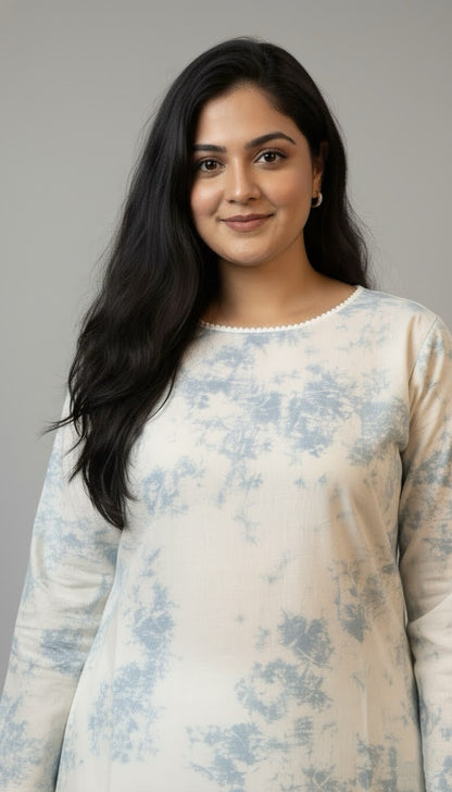 Woman wearing a light-colored floral dress against a plain background