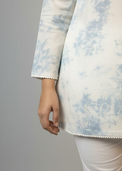 Close-up of a person wearing a light blue and white patterned coat against a gray background