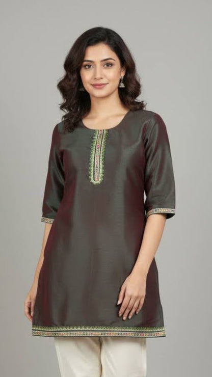 Woman wearing a dark green kurta with white pants on a gray background