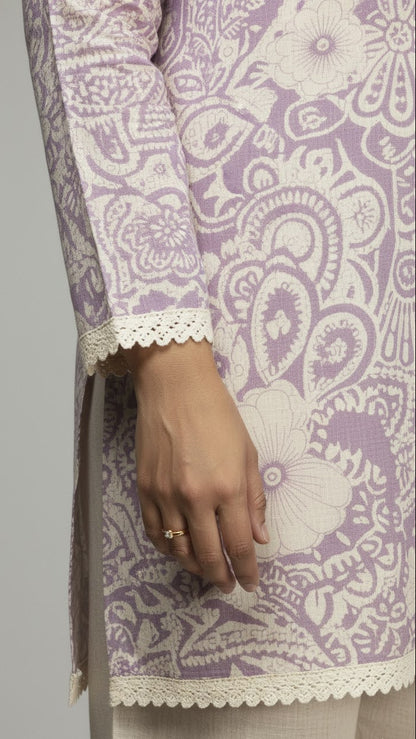 Close-up of a hand wearing a ring on a garment with intricate patterns.